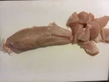 鶏むね肉をひと口大に切っています。