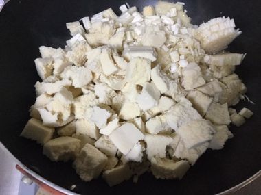 ちぎった高野豆腐とえのきのみじん切りをフライパンで炒めています。