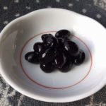 らっこが煮た黒豆です。白い小皿によそっています。