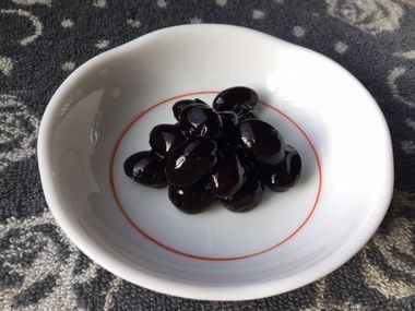 らっこが煮た黒豆です。白い小皿によそっています。