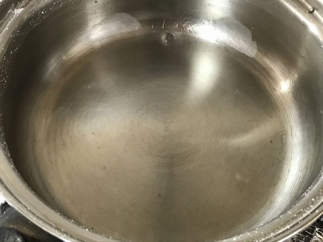 鍋に残った塩を取り出そうとしています。